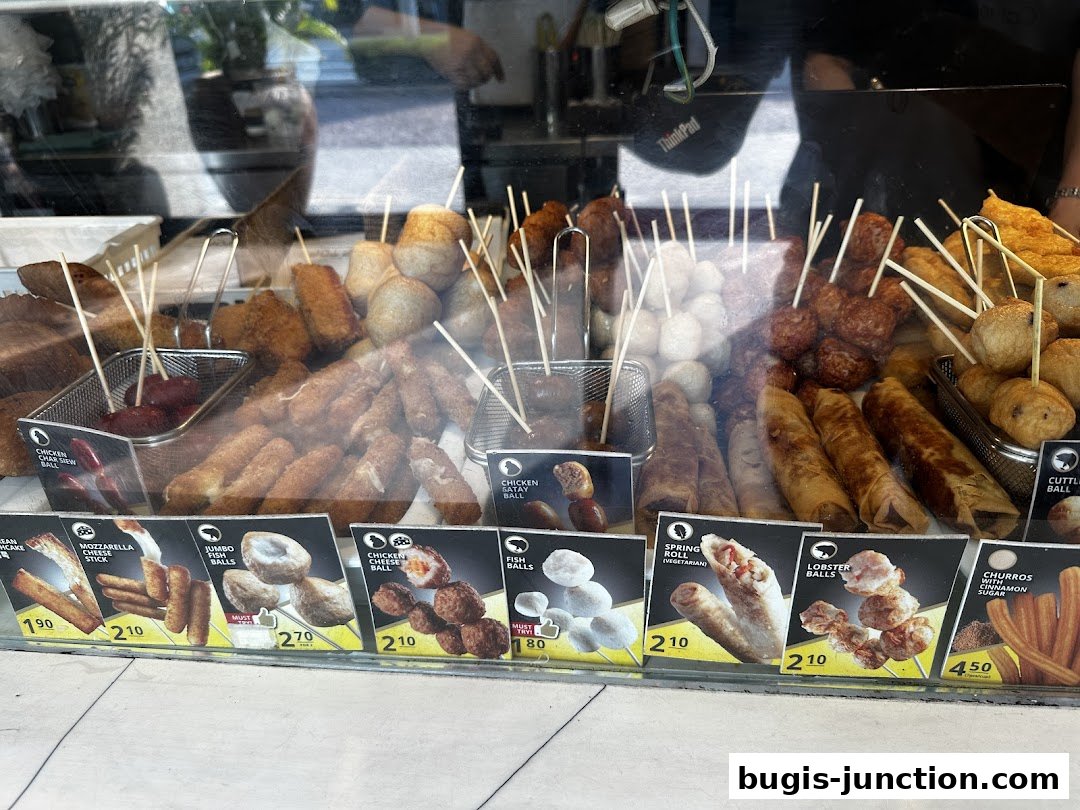 A display of various fried snacks on sticks, including spring rolls and meatballs.