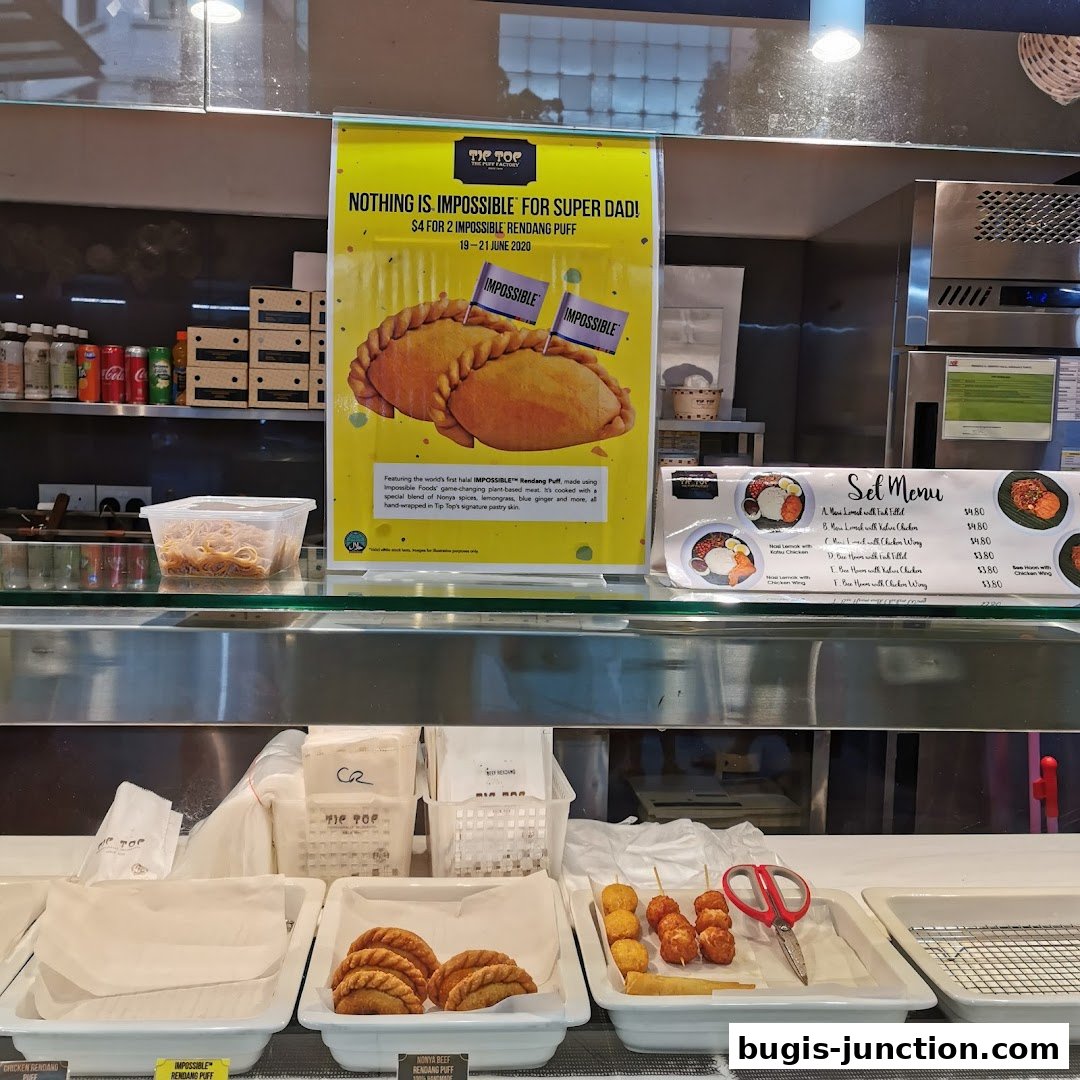 A display counter at Tip Top Curry Puff featuring a special promotion and a set menu.