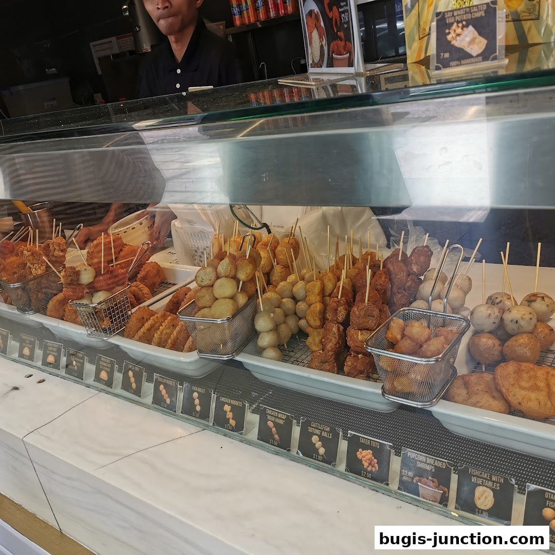 A display of various fried snacks on skewers at a food stall.