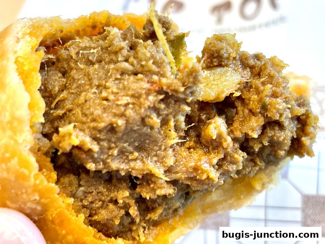 A close-up shot of a delicious curry puff, showcasing its savory filling and crispy pastry.