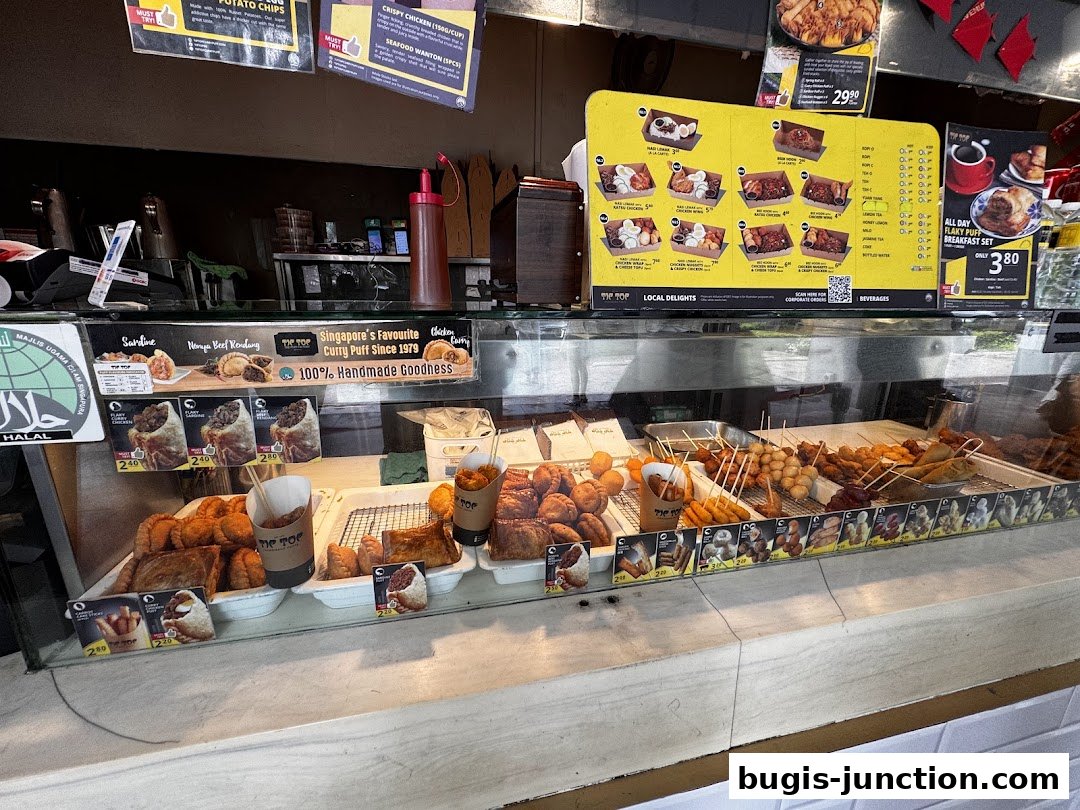 A display counter filled with various fried snacks and curry puffs from Tip Top Curry Puff.