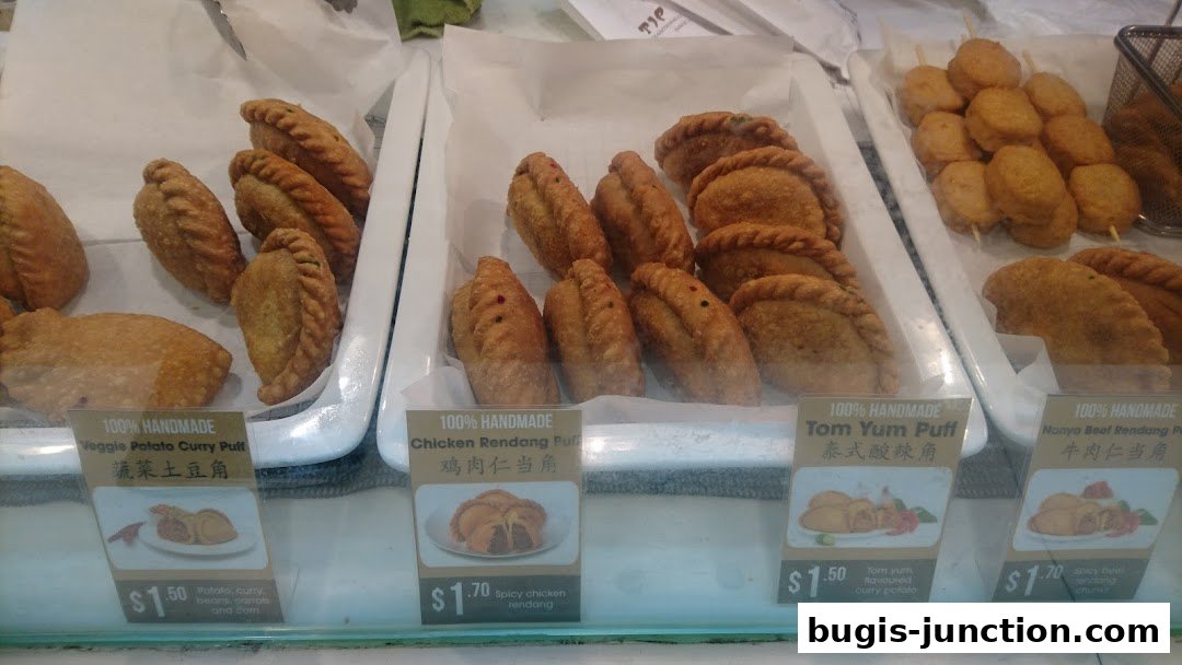A display of various handmade curry puffs and snacks at Tip Top Curry Puff.