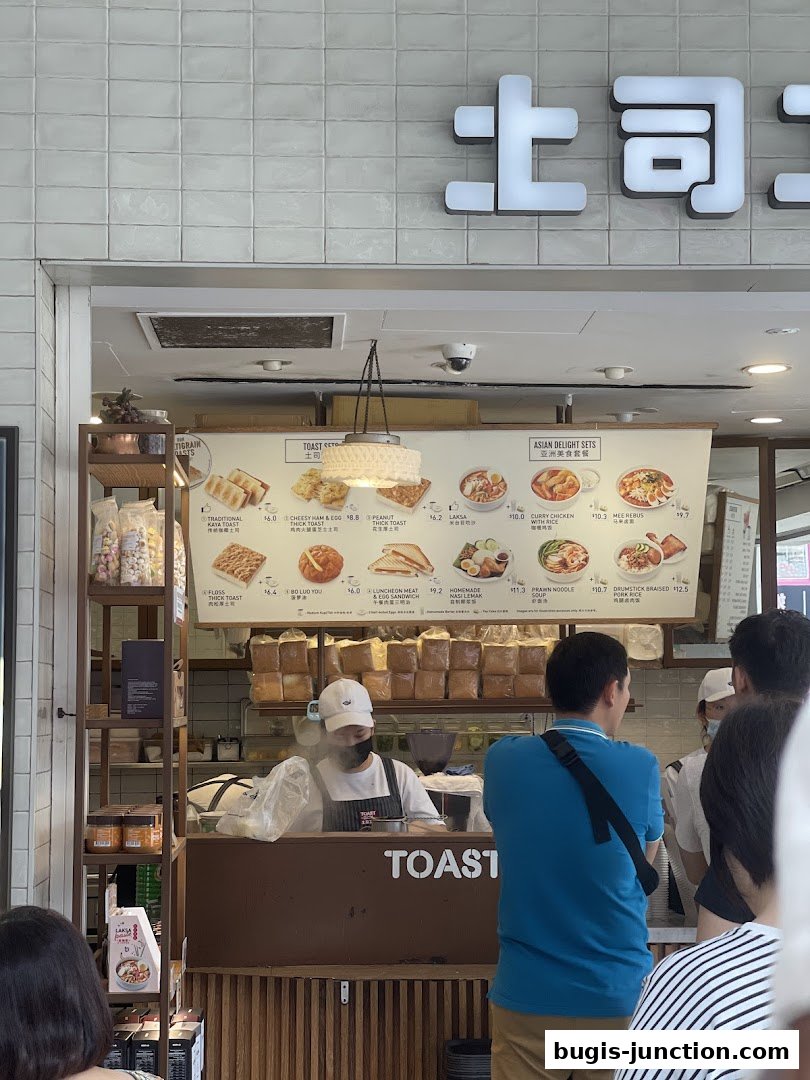 A menu board displays various toast and Asian delight sets with prices.