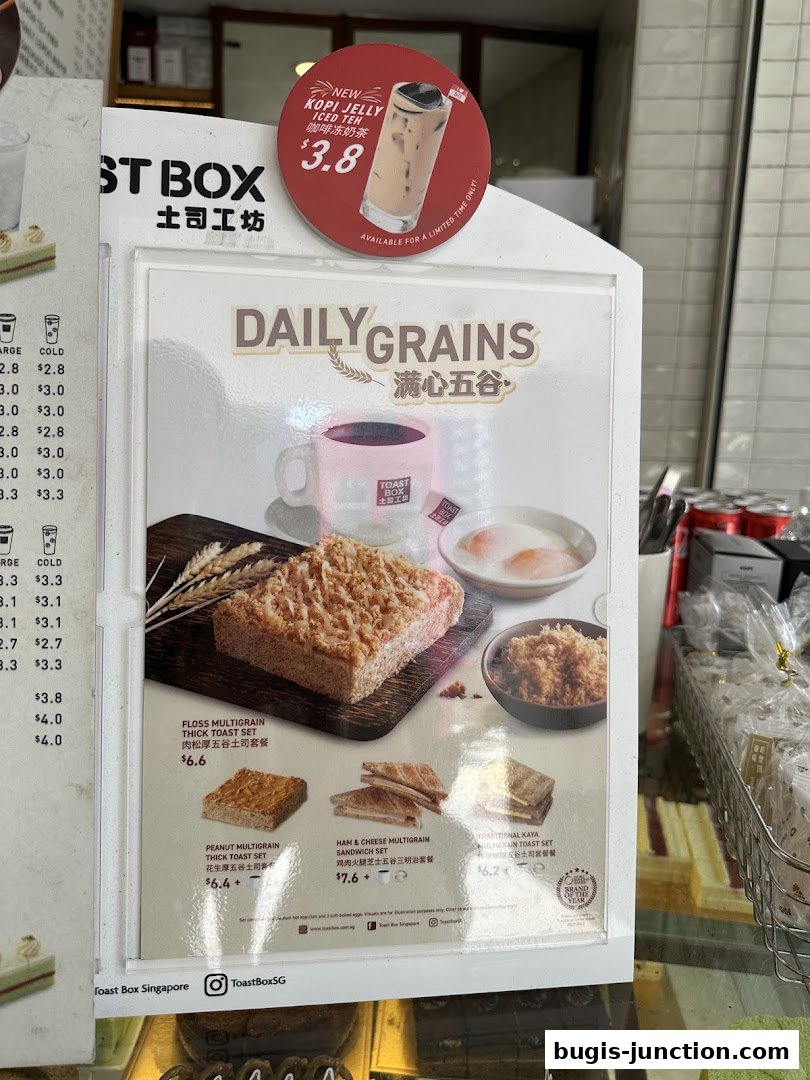 A menu board from Toast Box featuring daily grain toast sets and a new Kopi Jelly Iced Teh.