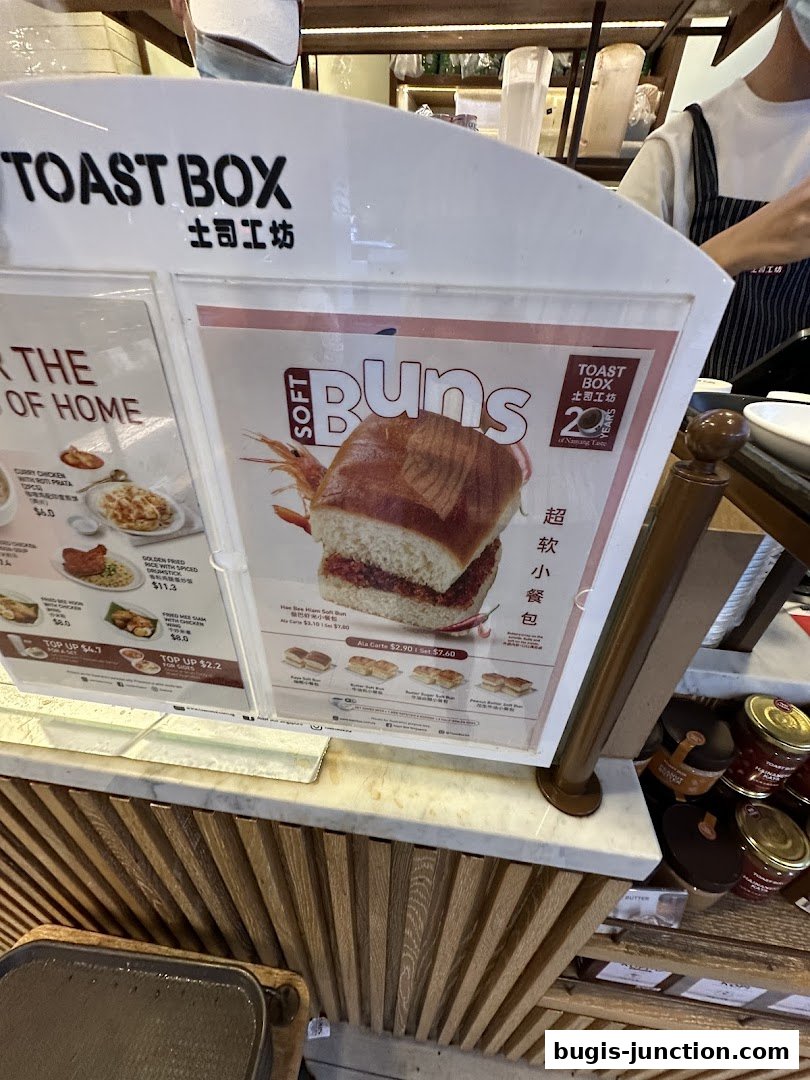 A menu board displaying various soft buns and other food items from Toast Box.