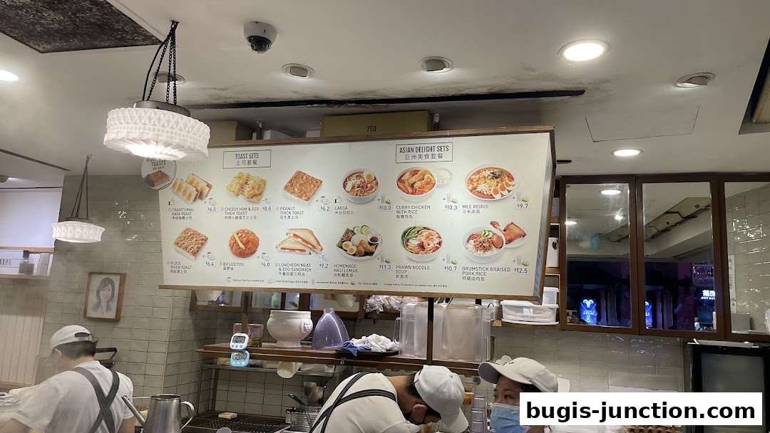 A menu board displaying various toast sets and Asian delight sets with prices.