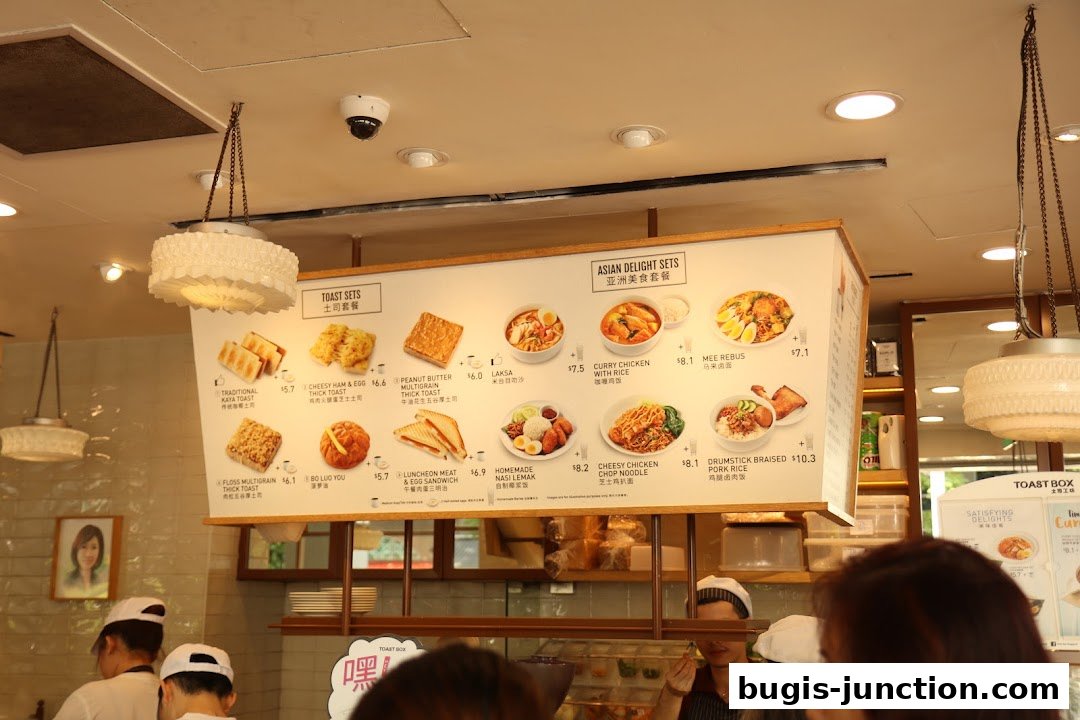 A menu board displaying various toast sets and Asian delight sets with images and prices.