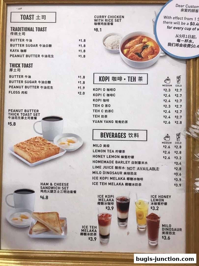 A menu board displaying various toast sets, beverages, and a curry chicken rice set.