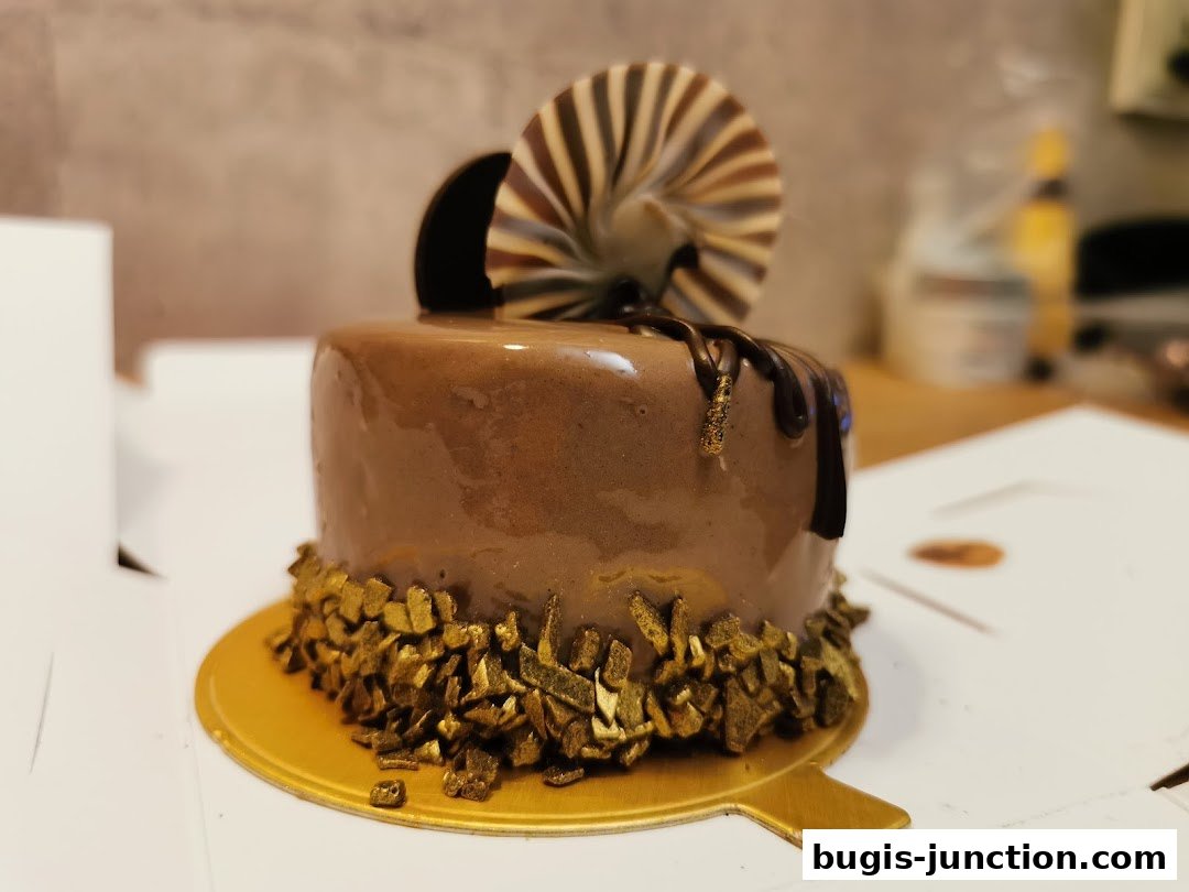 A decadent chocolate cake with glossy frosting, chocolate drizzle, and gold leaf accents.
