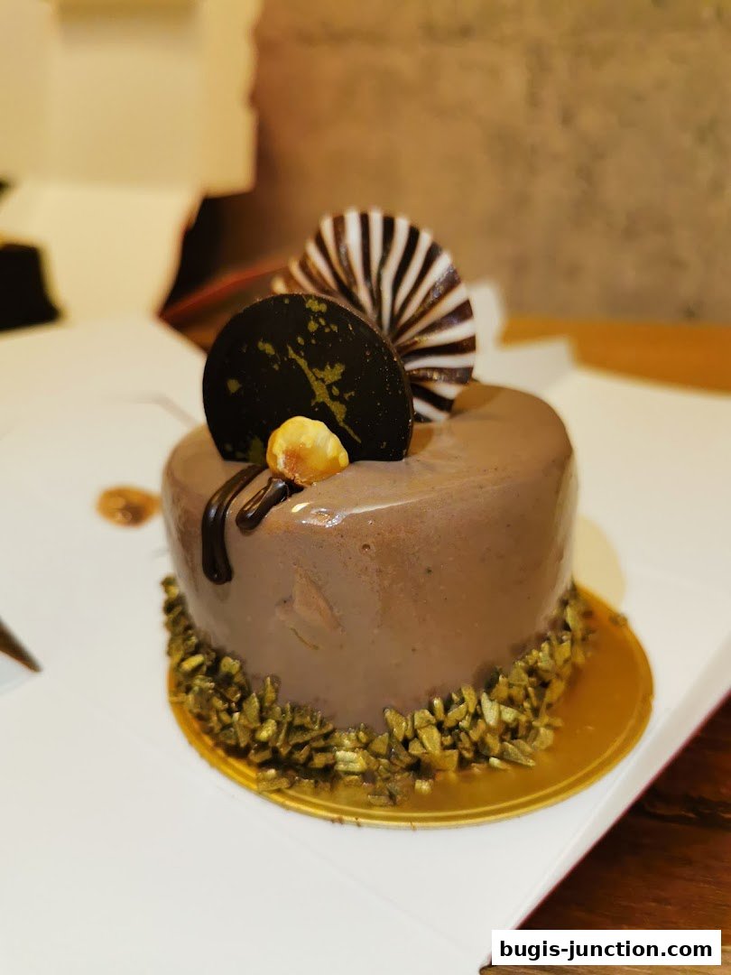 A beautifully decorated chocolate cupcake with hazelnut and chocolate garnishes.