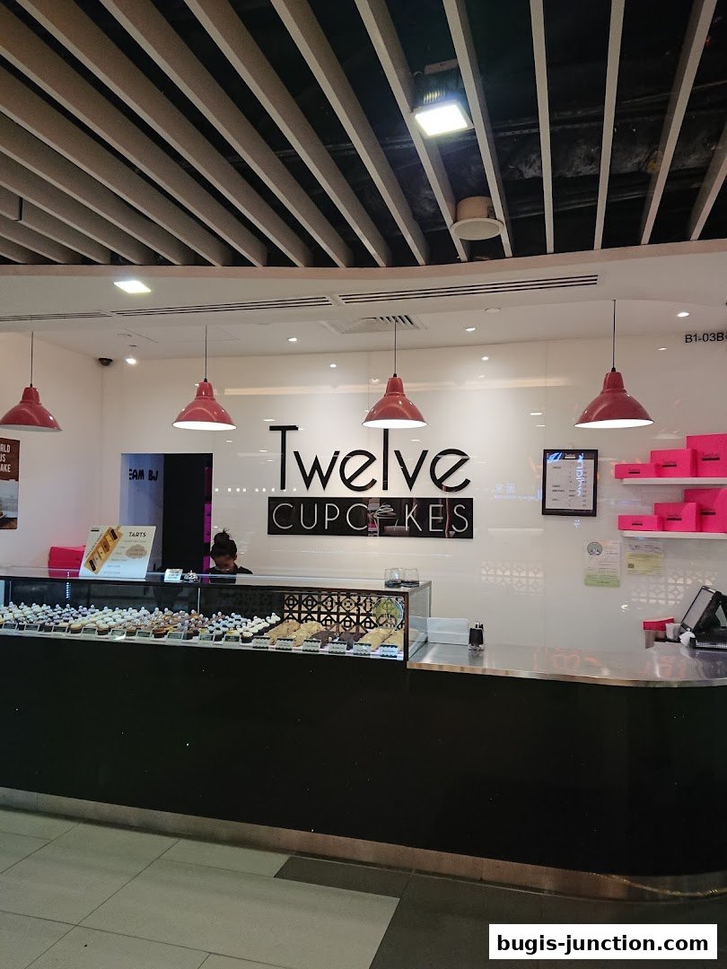 A display counter filled with cupcakes and pastries at Twelve Cupcakes.