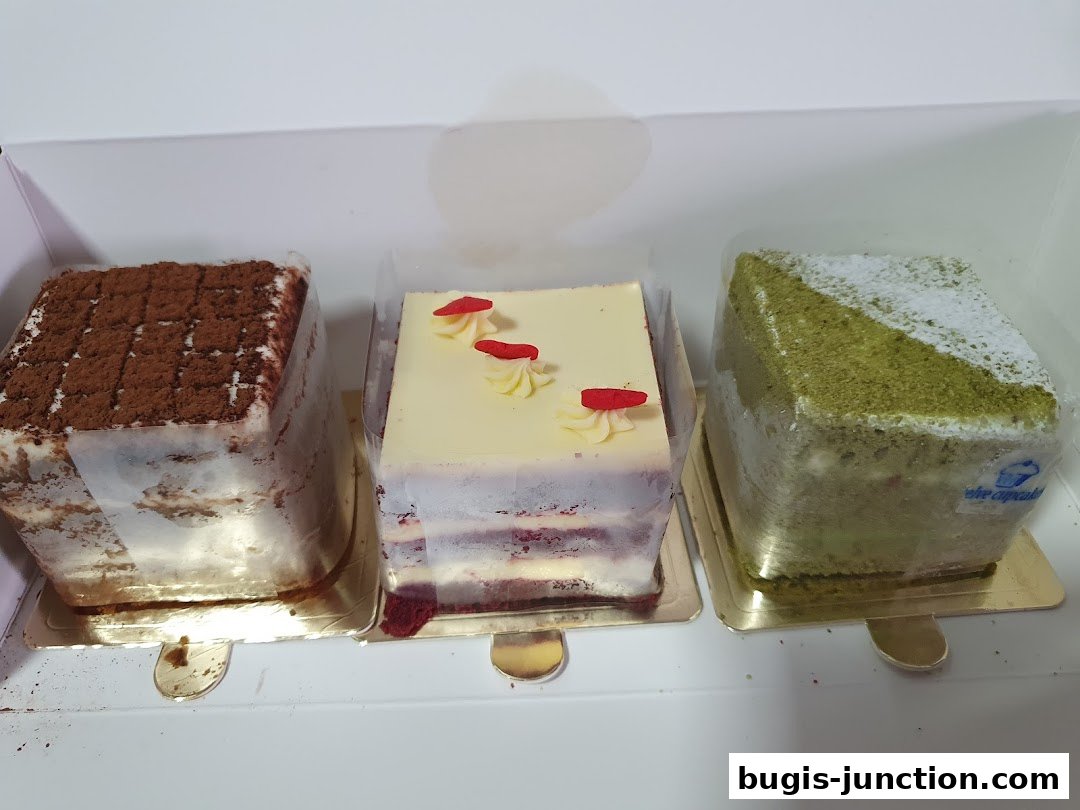 Three square cakes in a box: one chocolate, one red velvet, and one matcha.