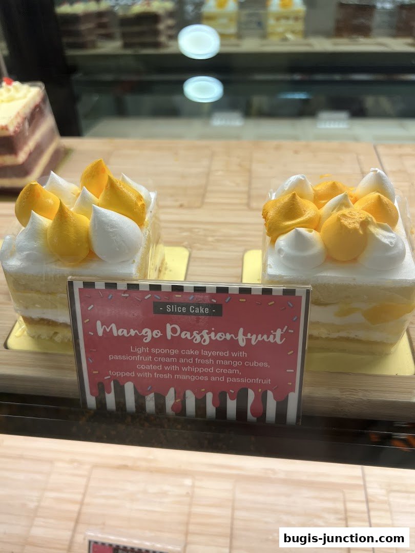 A close-up of two delicious Mango Passionfruit slice cakes with whipped cream and mango toppings.