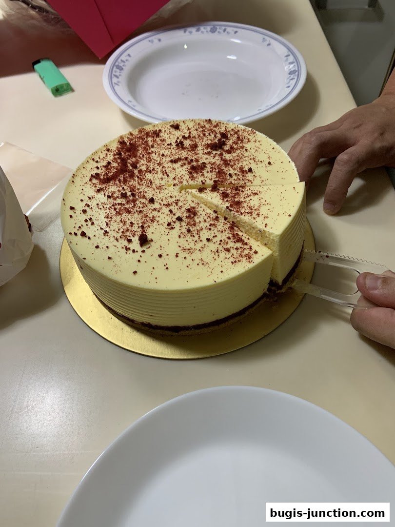 A red velvet cake is being sliced on a table with plates and a lighter.