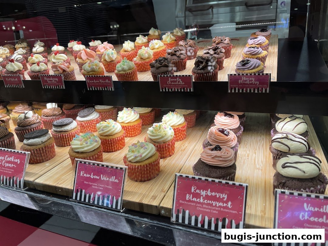 A display case filled with a variety of colorful and decorated cupcakes.