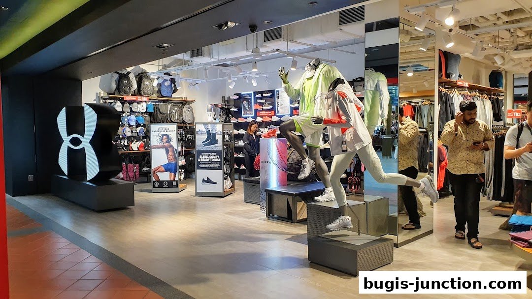 Interior of an Under Armour store with mannequins, sportswear, and accessories on display.