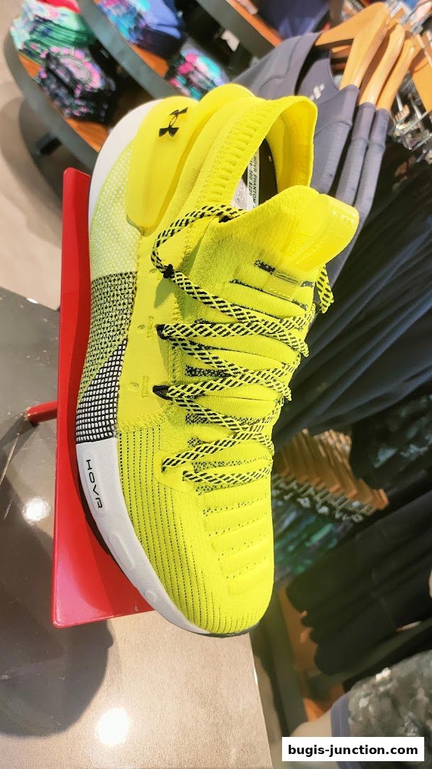 A bright yellow Under Armour HOVR Phantom running shoe is displayed prominently.