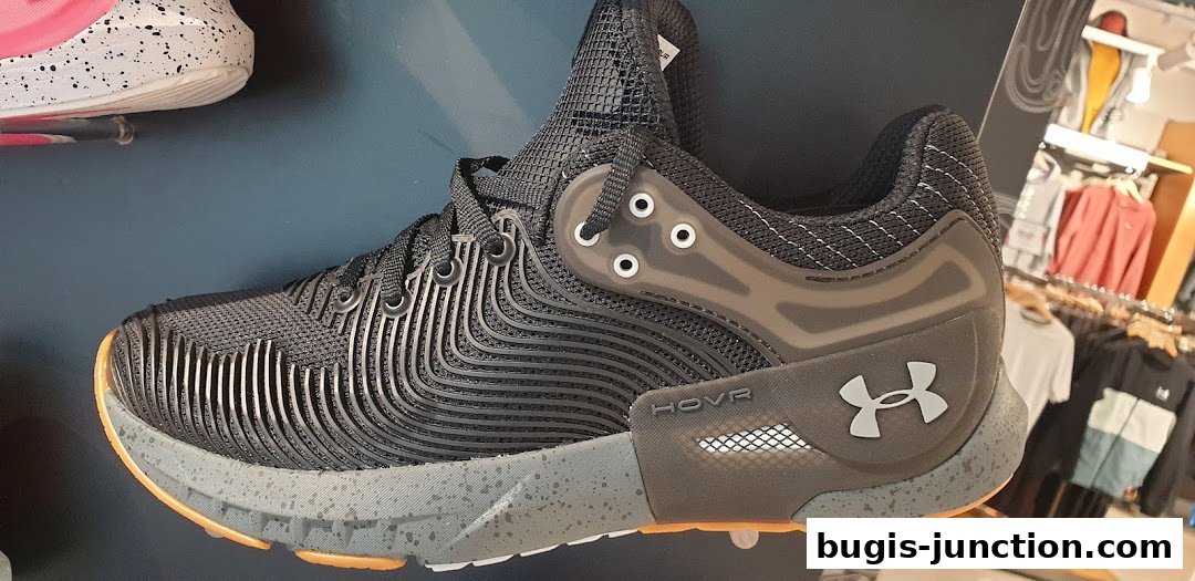 Close-up of a black Under Armour HOVR athletic shoe with a speckled grey sole.