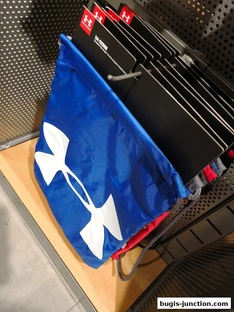 A blue Under Armour drawstring bag with a large white logo is displayed.