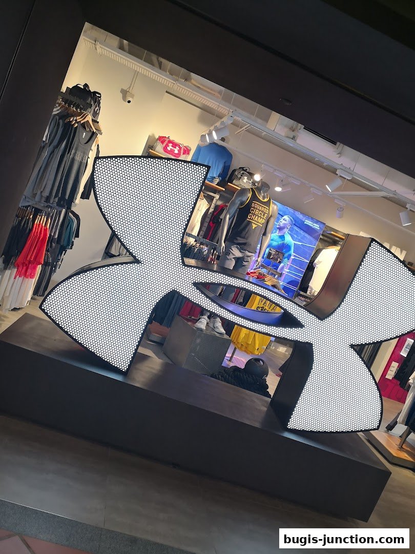 Under Armour store interior with large logo and mannequins displaying athletic wear.