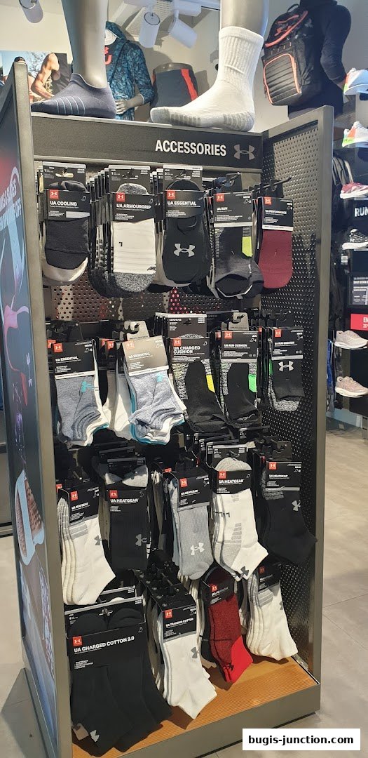 Display of various Under Armour socks, including ankle and crew styles, in a retail store.