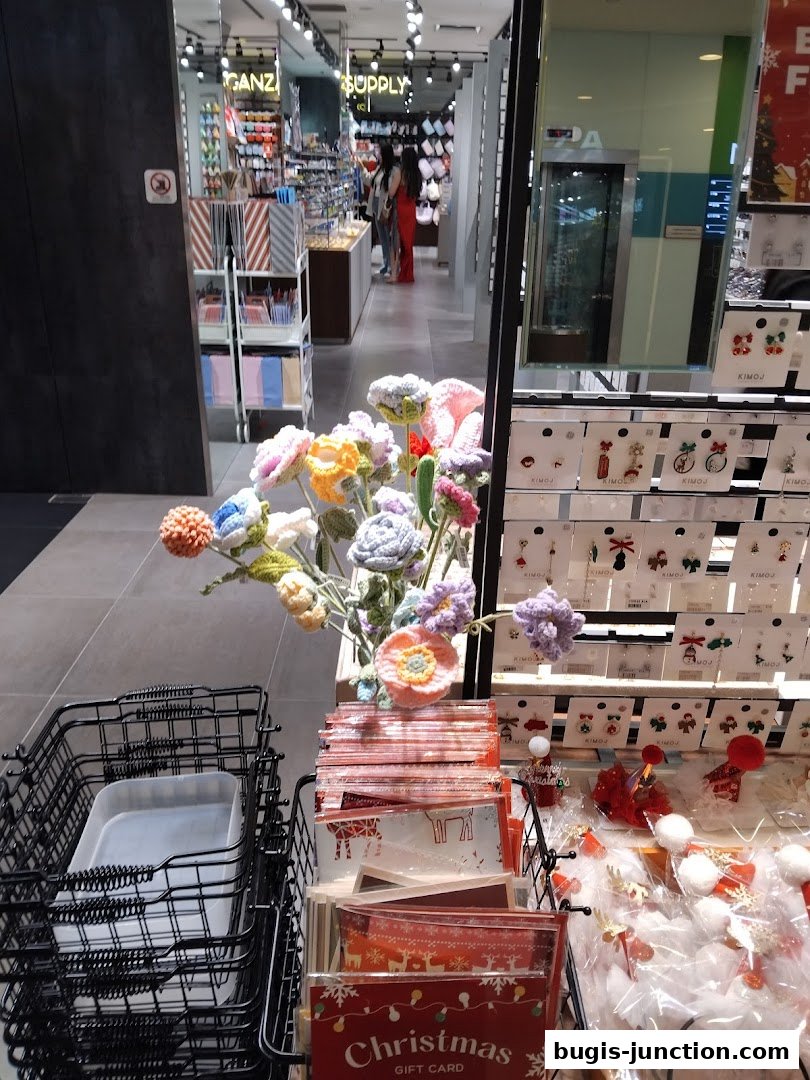 A shop interior with colorful crochet flowers, gift cards, and various accessories displayed.
