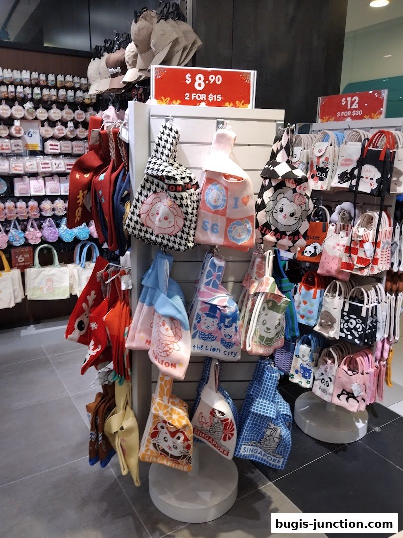 A display of various tote bags with cute animal and Singapore-themed designs.