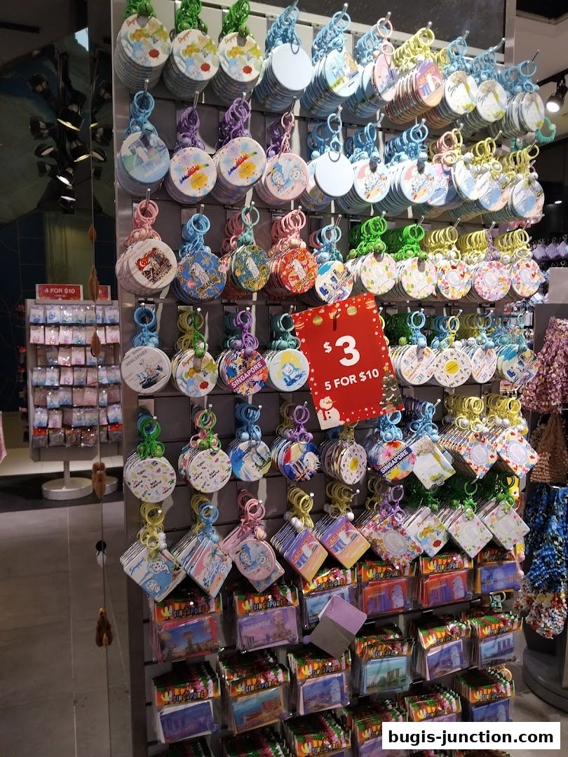 A display wall filled with colorful Singapore-themed keychains and souvenirs.