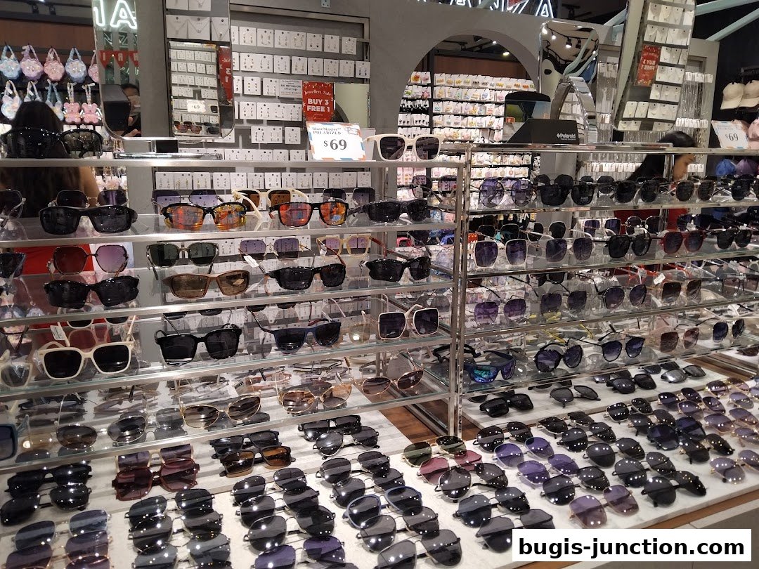A wide selection of sunglasses displayed on shelves in a retail store.