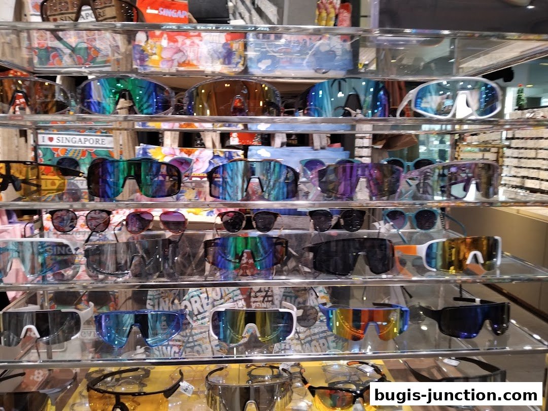 A display of various sunglasses and eyewear on shelves in a retail store.