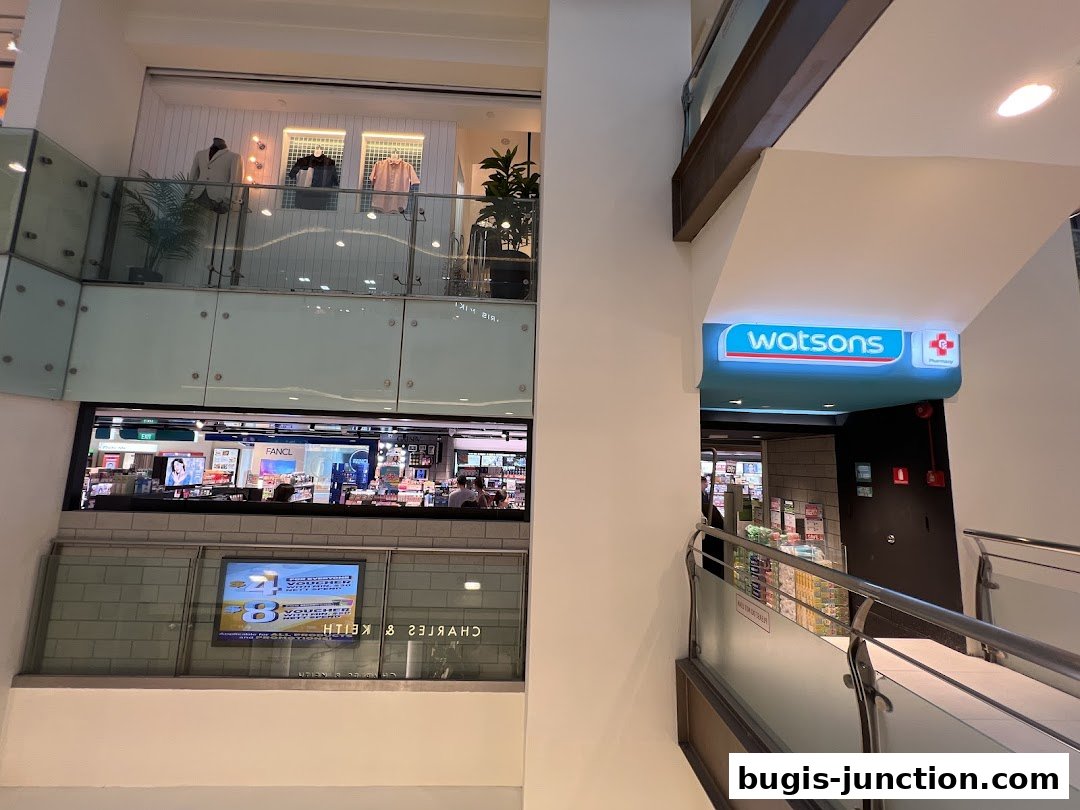 A Watsons Pharmacy store entrance with a prominent illuminated sign and products visible inside.
