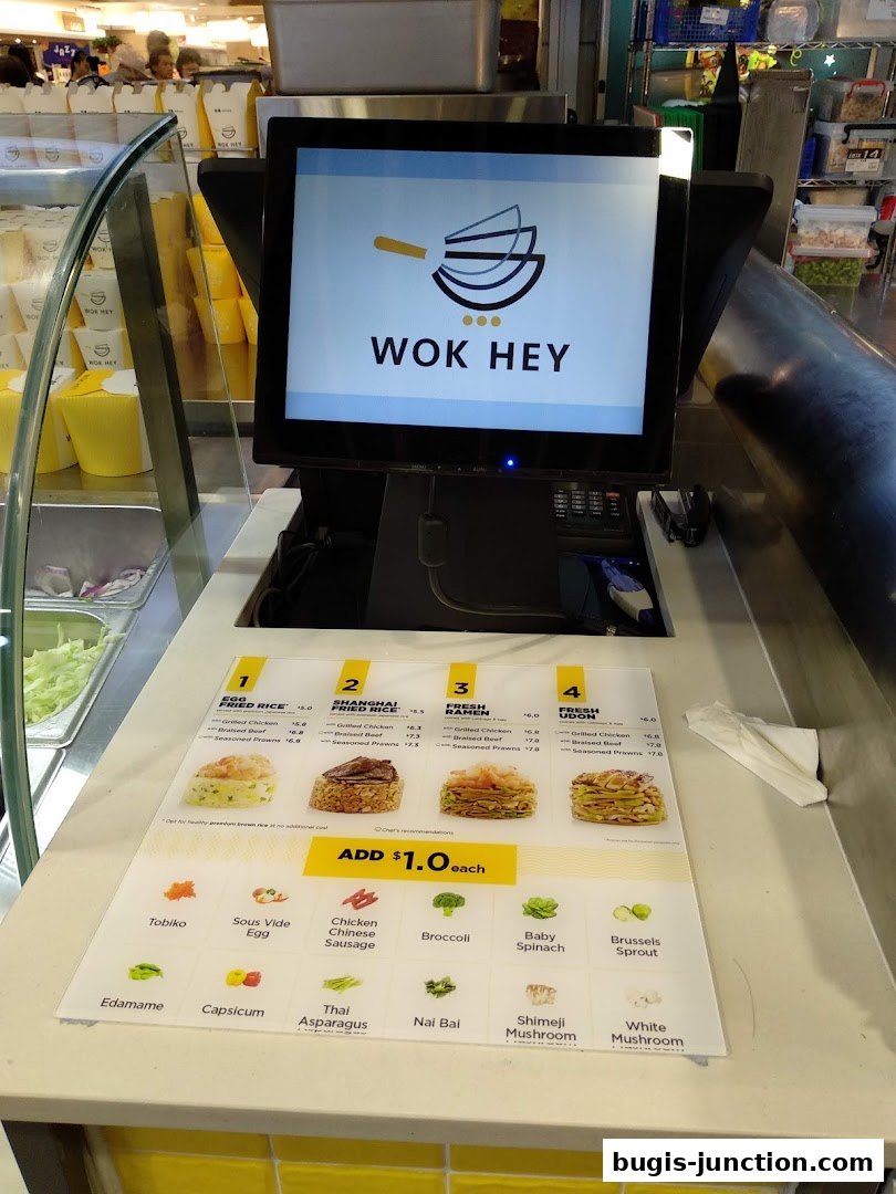 A Wok Hey counter displaying a menu with food items and customization options.