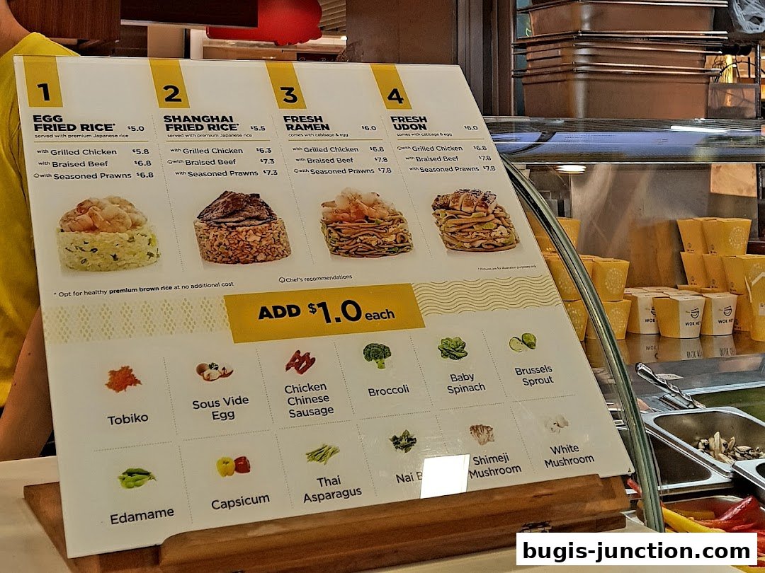 A menu board for Wok Hey Bugis Junction showcasing various rice, ramen, and udon dishes with protein options.