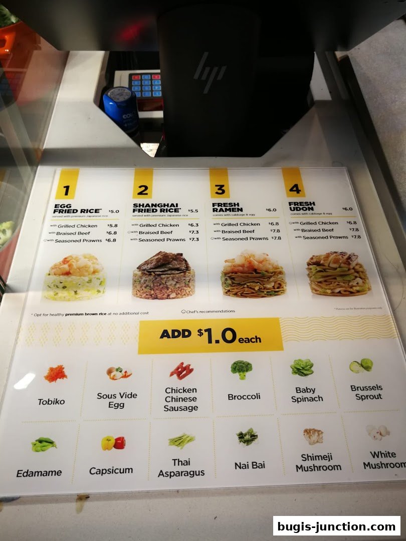 A menu board displaying various rice, ramen, and udon dishes with add-on ingredients.