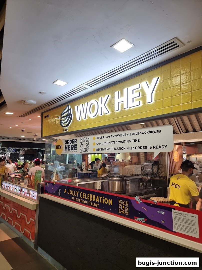 The Wok Hey shop front with bright yellow tiles and a prominent logo.