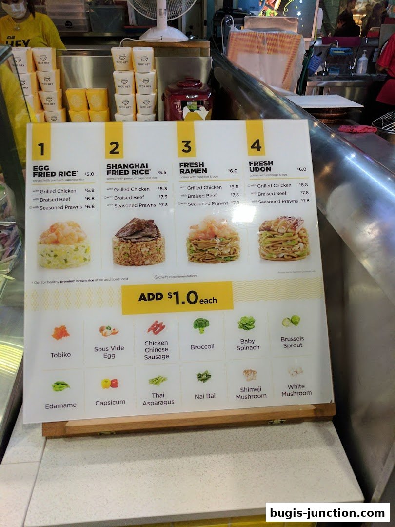 A menu board for Wok Hey Bugis Junction, showcasing various rice, ramen, and udon dishes with customization options.