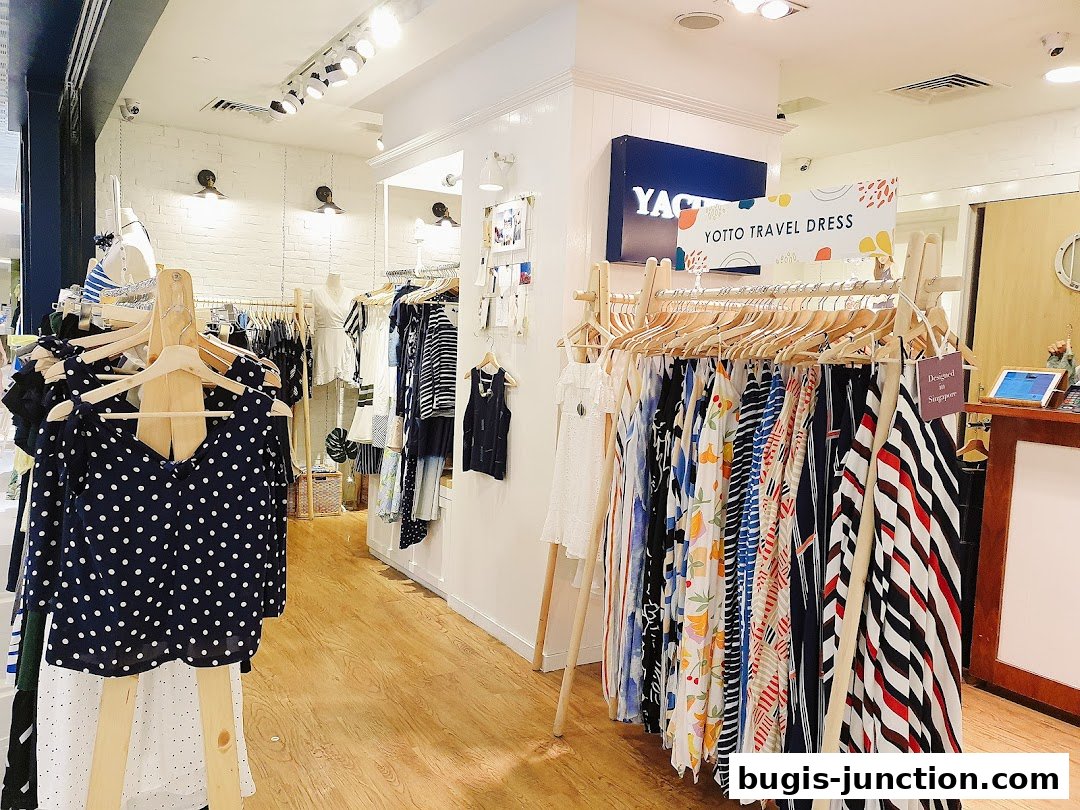 Interior view of a clothing store with racks of dresses and tops.