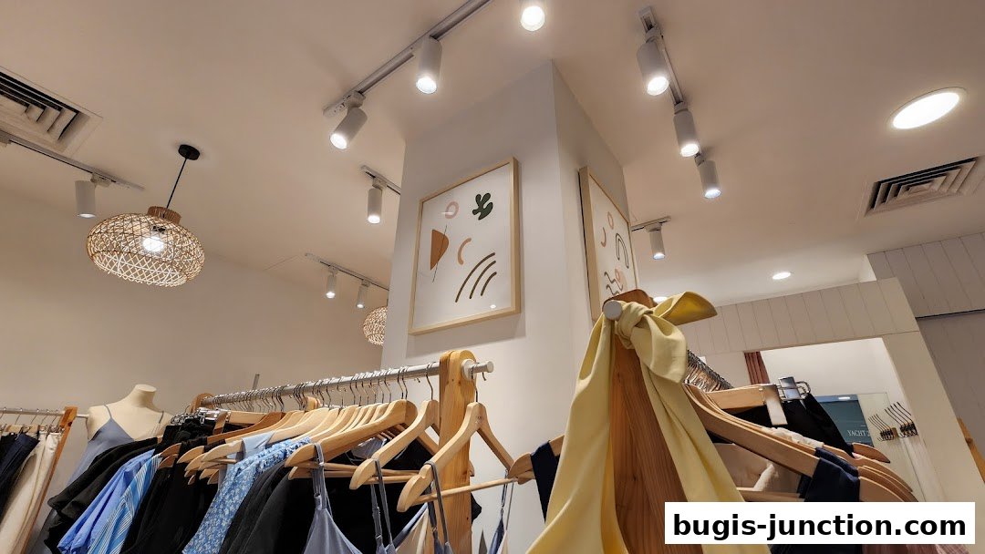 Interior view of a clothing store with racks of apparel and decorative art.