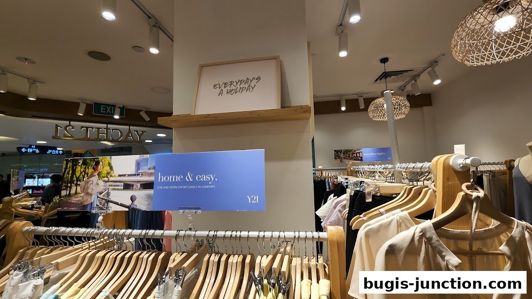 Interior view of a clothing store with racks of apparel and decorative lighting.
