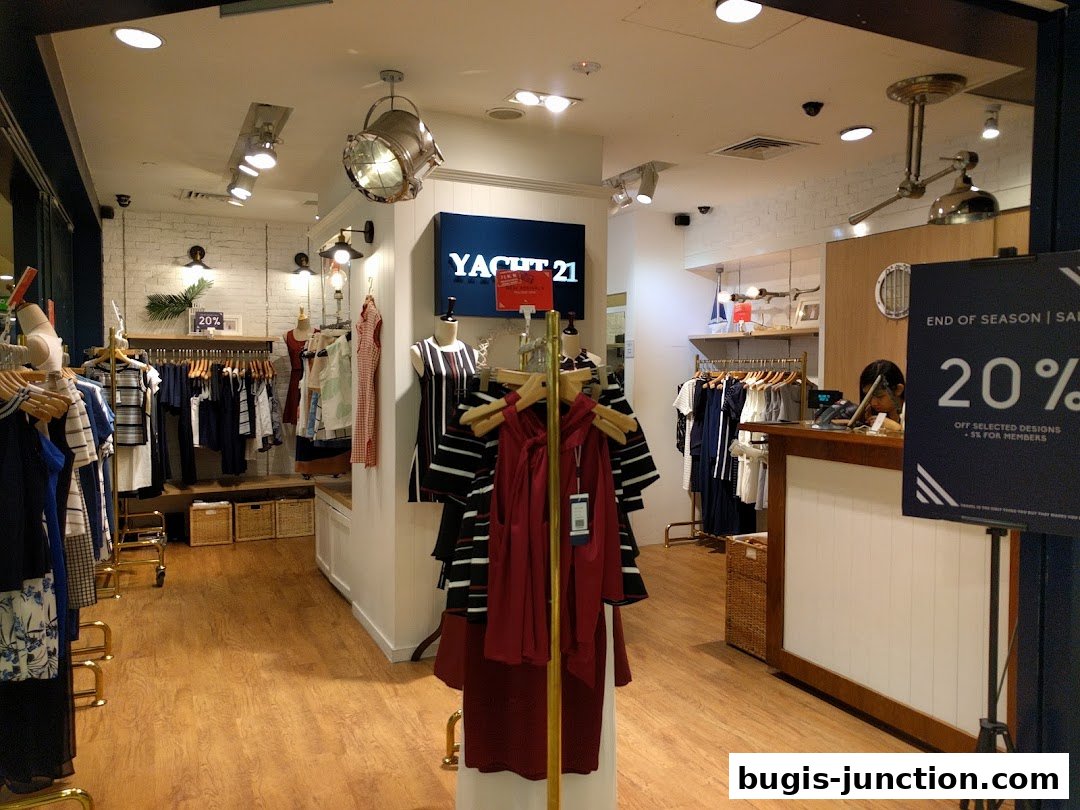 Interior view of a clothing store with racks of apparel and a checkout counter.