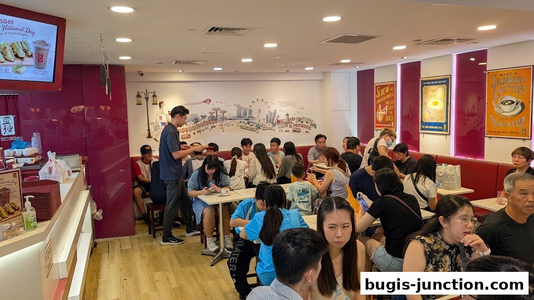 Interior of Ya Kun Kaya Toast with customers dining and a display of food and drinks.