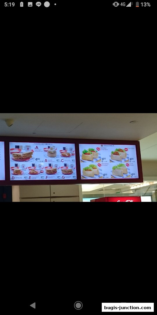 Digital menu boards displaying value set meals and toast sticks at Ya Kun Kaya Toast.