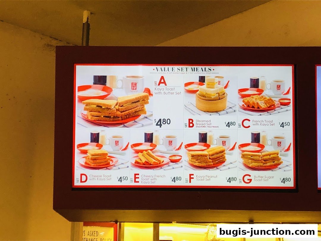 A digital menu board displaying various value set meals from Ya Kun Kaya Toast.