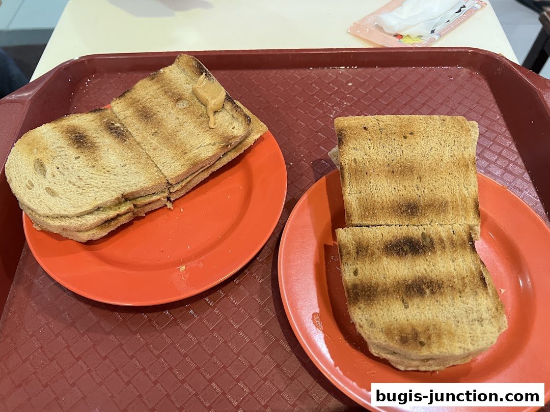 Two plates of kaya toast with peanut butter on a tray.