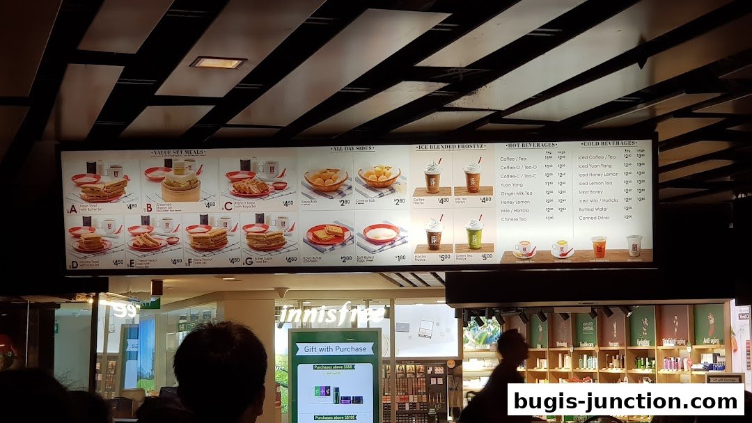 A menu board displaying set meals, sides, iced drinks, hot beverages, and cold beverages.