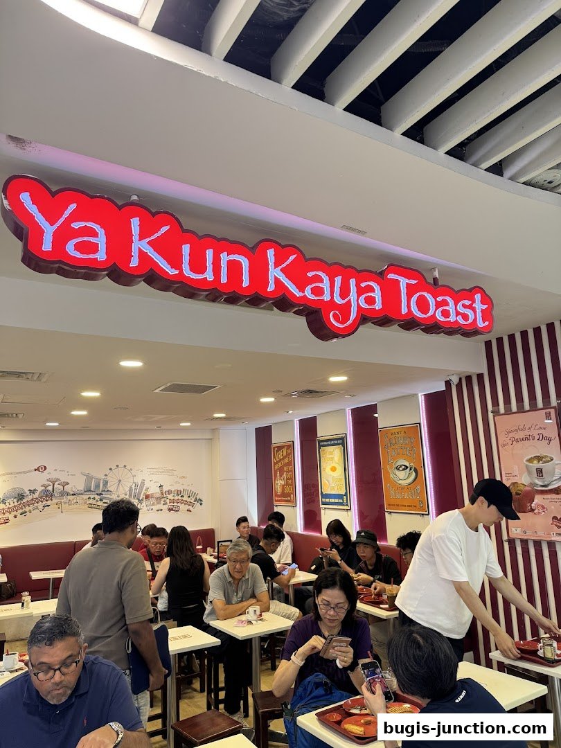 Interior of Ya Kun Kaya Toast with customers dining and a prominent sign.