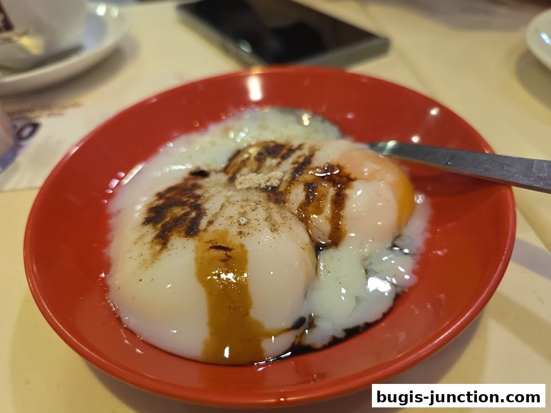 A close-up of soft-boiled eggs with soy sauce and pepper in a red bowl.