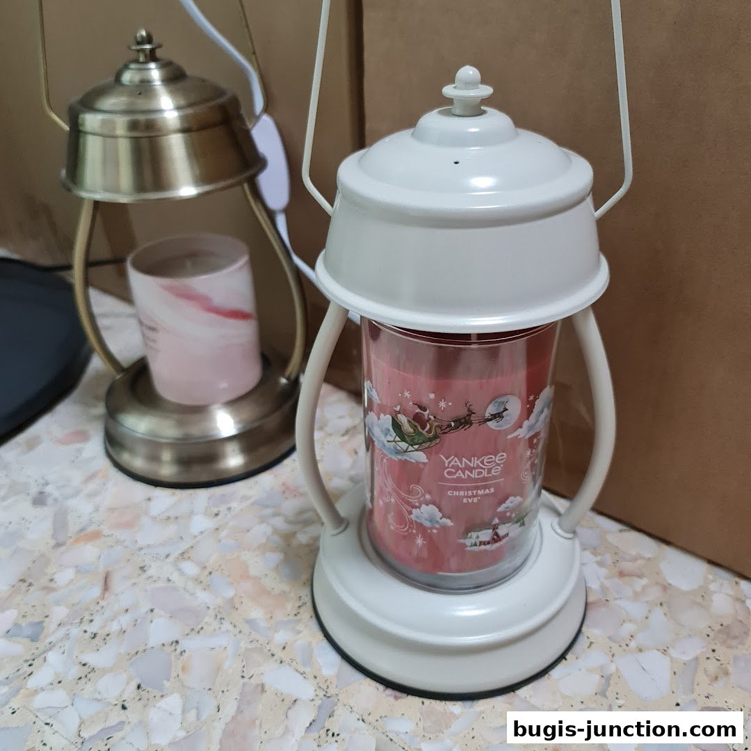 Two Yankee Candle wax melt warmers with candles inside, one white and one brass.