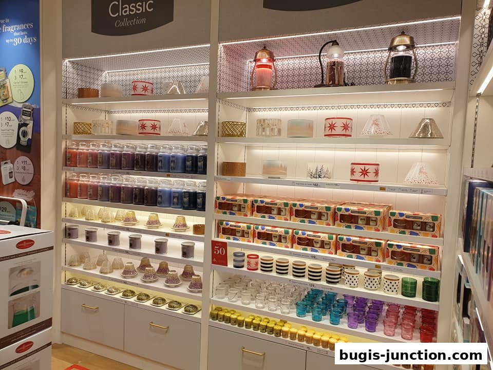 A well-lit display of Yankee Candles and accessories, featuring various sizes and scents.