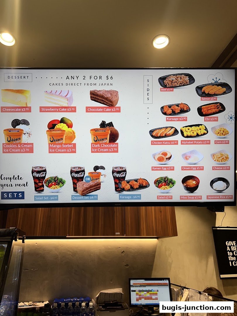 A digital menu board displaying desserts, sides, and meal sets with prices.